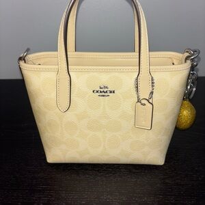 City Mini Tote Bag In Signature Canvas  in color Hay. Charm not included